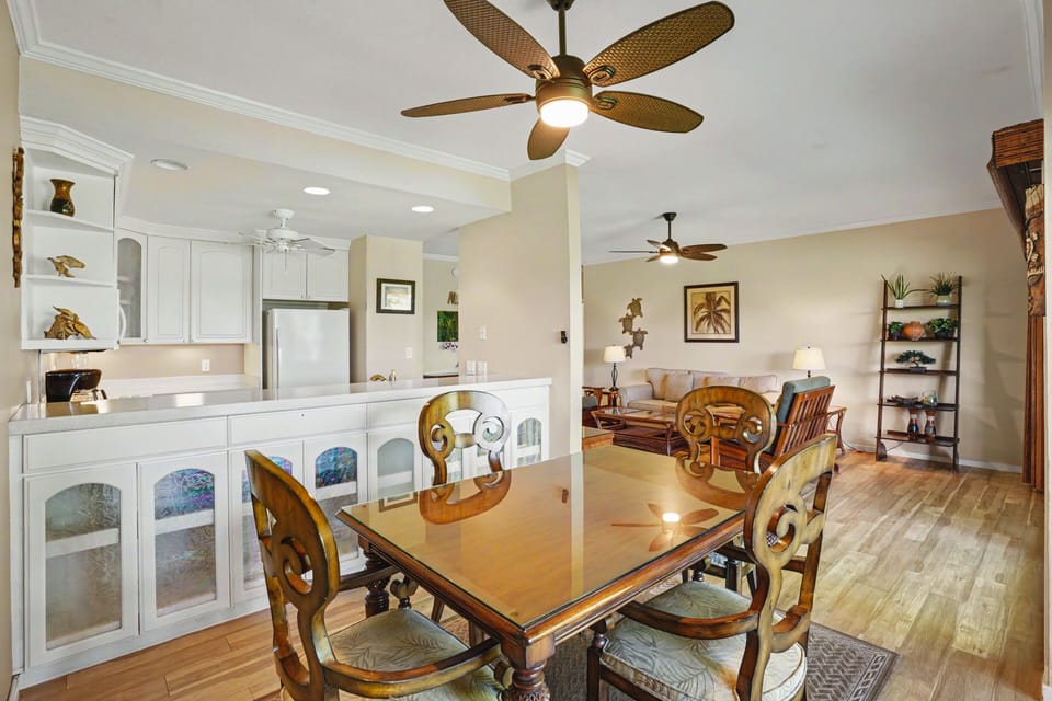 Step into your bright open-concept living and dining space with warm wood floors, tropical-inspired décor, and coastal charm that invites you to relax and feel at home.