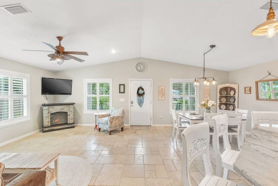 View the living room and dining room spaces panned out. You can also see the front door.