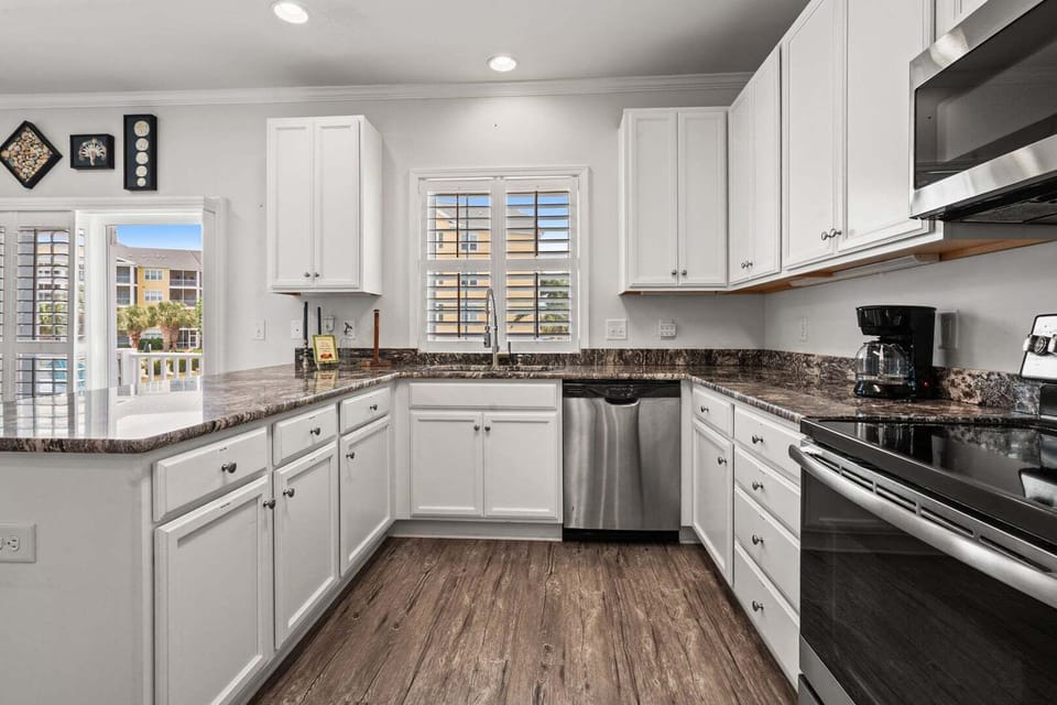 White cabinetry and dark counters in the kitchen at Ocean Keyes 1301, a 4-bedroom North Myrtle Beach rental