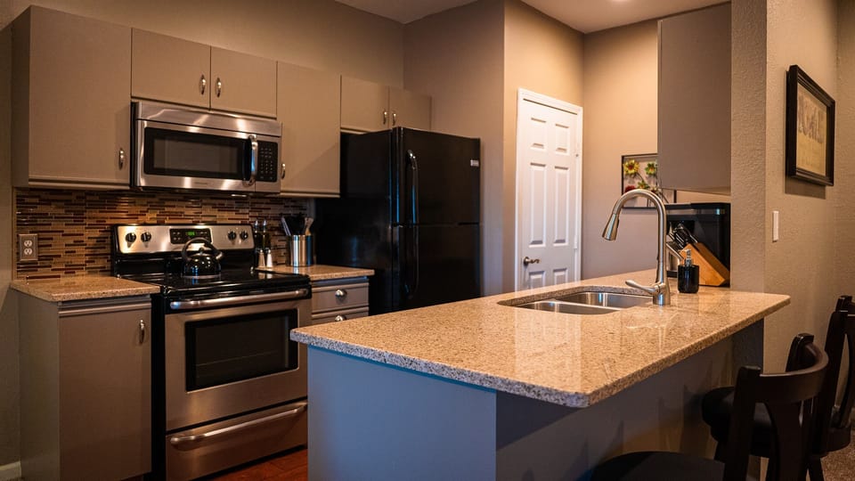 Well-appointed kitchen with granite countertops standard-sized fridge/freezer, stove, oven, microwave, dishwasher, and Bunn coffee maker and grinder.