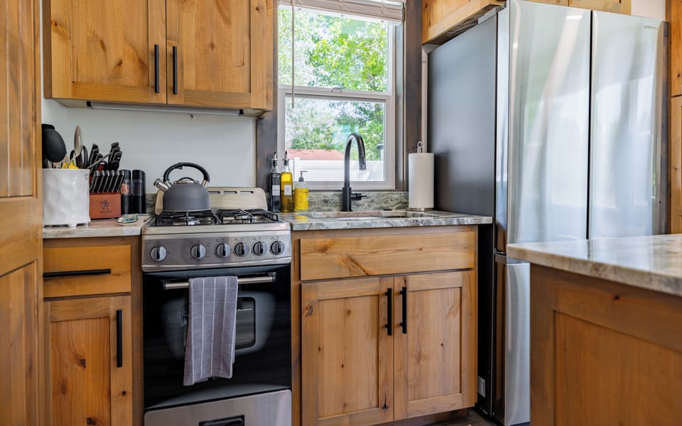 Kitchenette with gas oven and stove, sink, full-sized refridgerator and island.