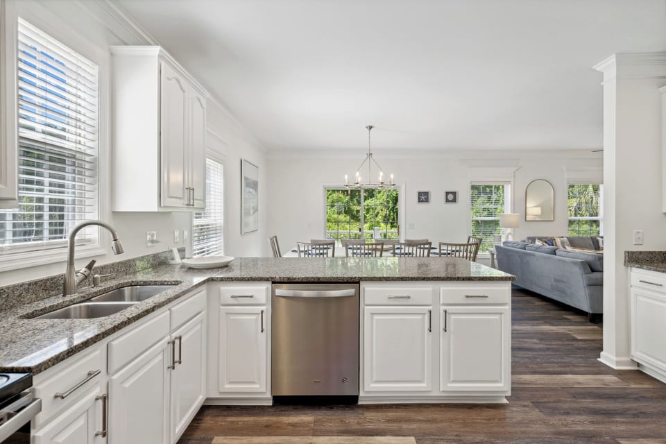 The spacious living room features ample seating and large windows that bring the outdoors inside, creating the perfect setting for comfort and relaxation.