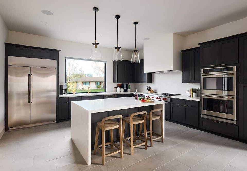 (1st Floor) Fully equipped kitchen with stainless steel appliances, cooking essentials, and kitchen island bar seating.