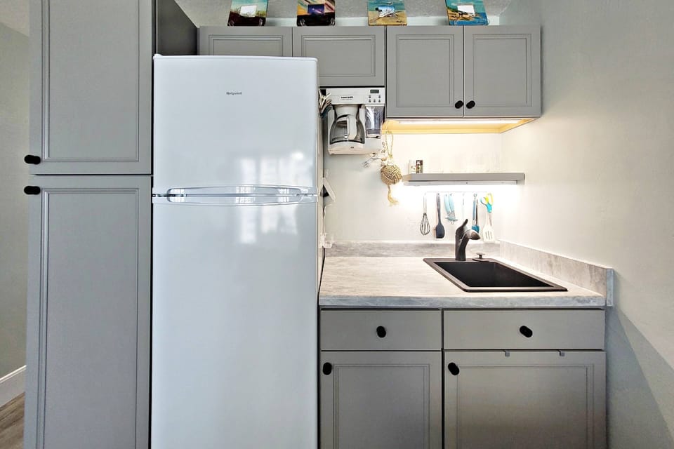 Kitchenette equipped with a refrigerator/freezer, coffee maker, cookware, plates, utensils,...