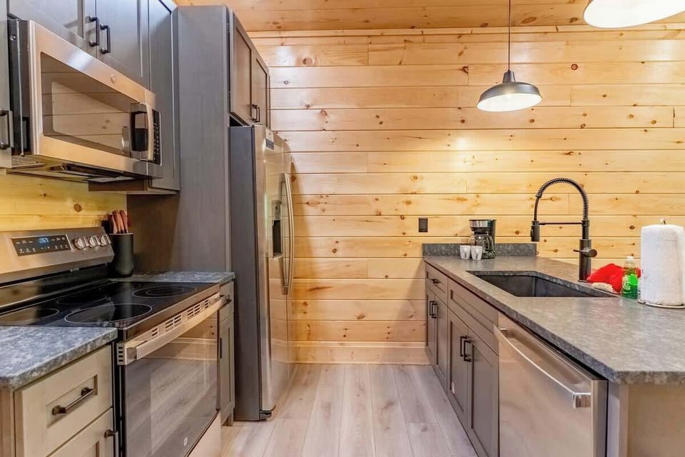 Cook up memories in this modern kitchen with sleek appliances and rustic wood accents!
