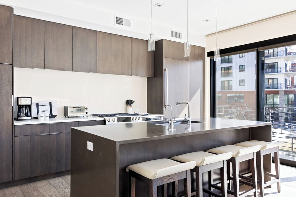 - Fully equipped kitchen with modern appliances and sleek design  
- Large island with bar seating perfect for cooking and dining  
- Floor to ceiling windows bring in natural light and resort views