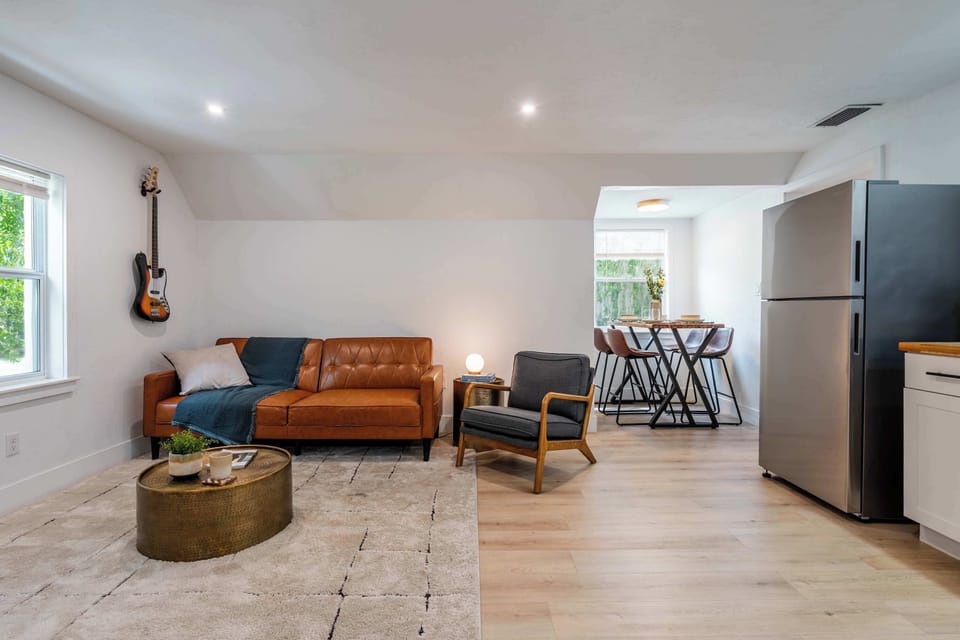 This open-concept living space blends industrial flair with mid-century comfort.