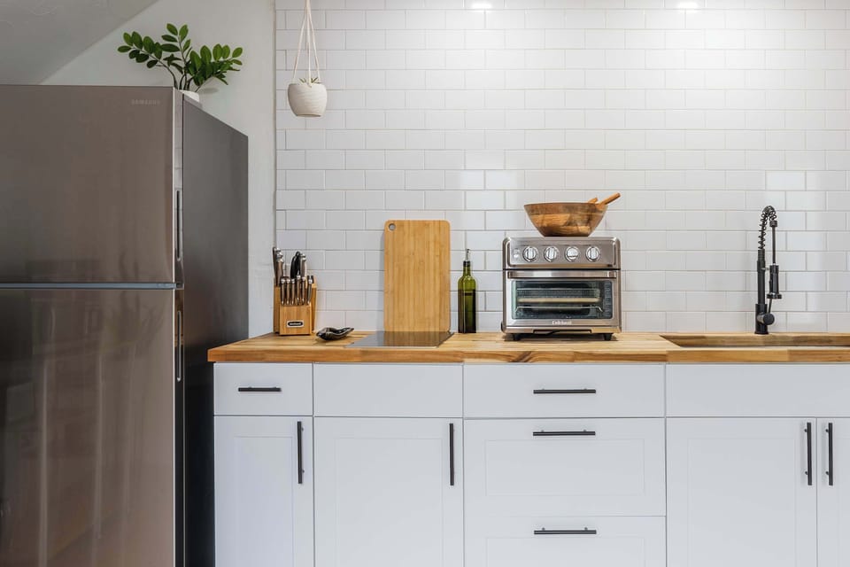 Cook with ease in our thoughtfully designed kitchen, featuring professional-grade knives, a versatile air fryer oven, and beautiful butcher block counters.