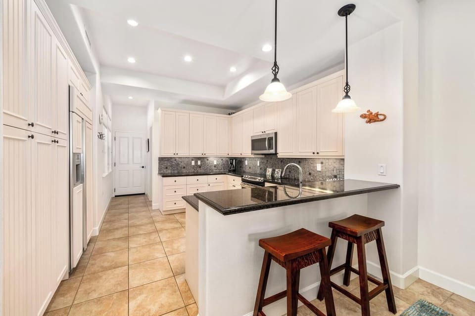 Full kitchen with granite countertops, stainless steel appliances, and breakfast bar