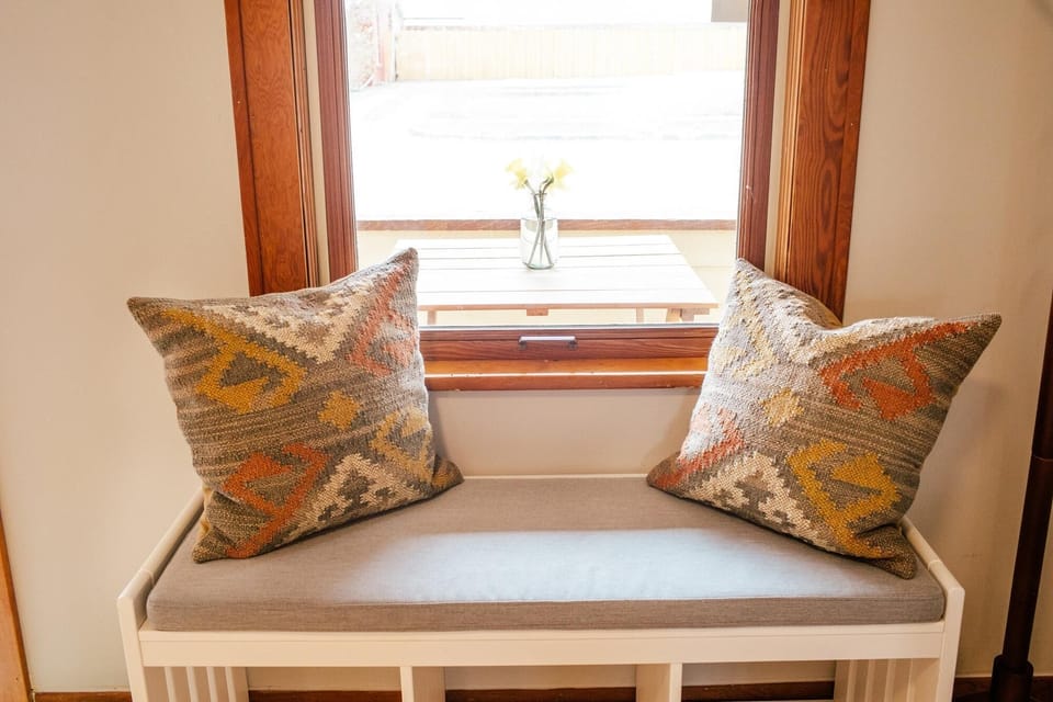 Cozy window nook with plush pillows for quiet moments