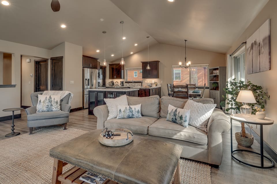 - Cozy living room with plush seating and modern cabin décor  
- Open floor plan flows into kitchen and dining for gatherings  
- Warm lighting and wood finishes create inviting mountain charm