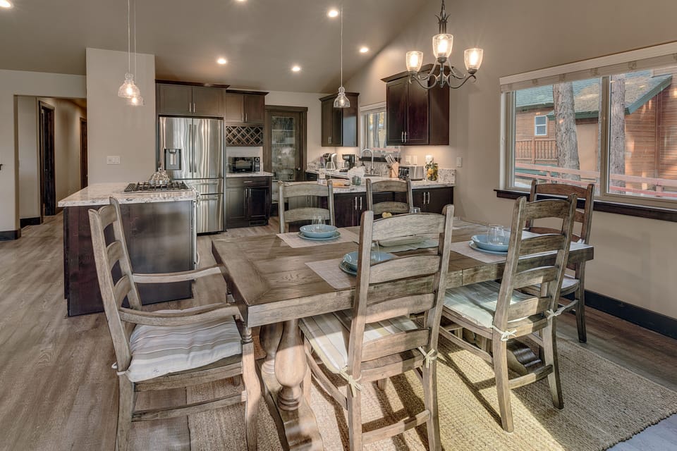 - Rustic dining table with seating for the whole group  
- Natural light fills the room with cabin neighborhood views  
- Gather for meals in a spacious kitchen dining retreat