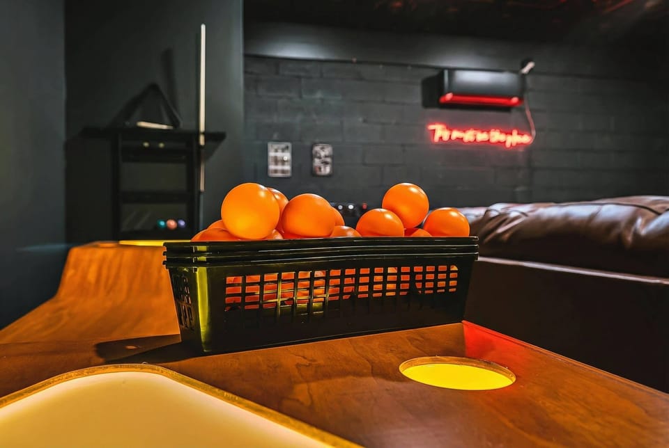 A glowing game table adds another layer of entertainment to the speakeasy-themed game room, because sometimes you need options beyond pool and karaoke to keep a group engaged