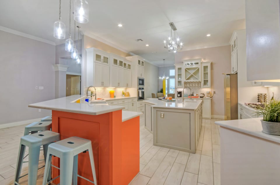 Fully equipped kitchen featuring mint barstools and an orange counter.