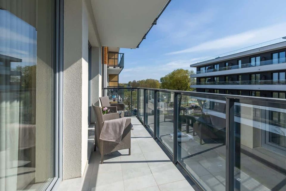 Spacious balcony with outdoor furniture. 