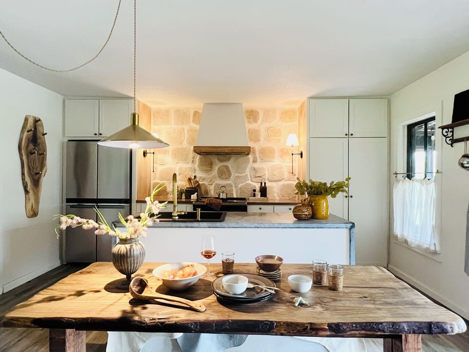 Chef's kitchen featuring stone walls, zinc island and butcher block counters