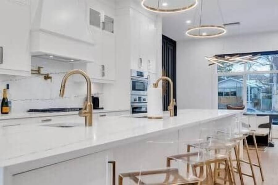 Chef's Kitchen with Quartz Counters and Backsplash and Gold Hardware