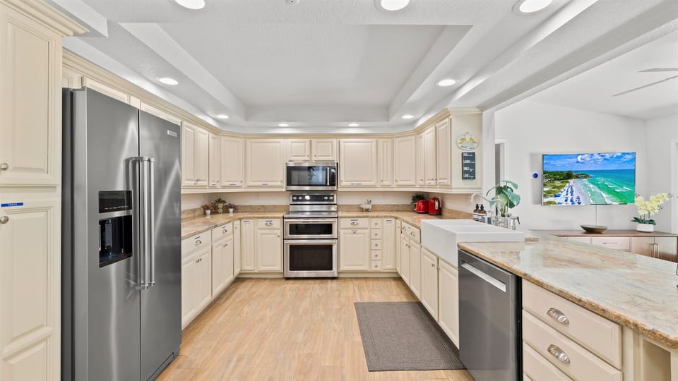 Bright, fully equipped kitchen with double oven, farmhouse sink, and sleek stainless steel appliances—ideal for home cooking and entertaining.