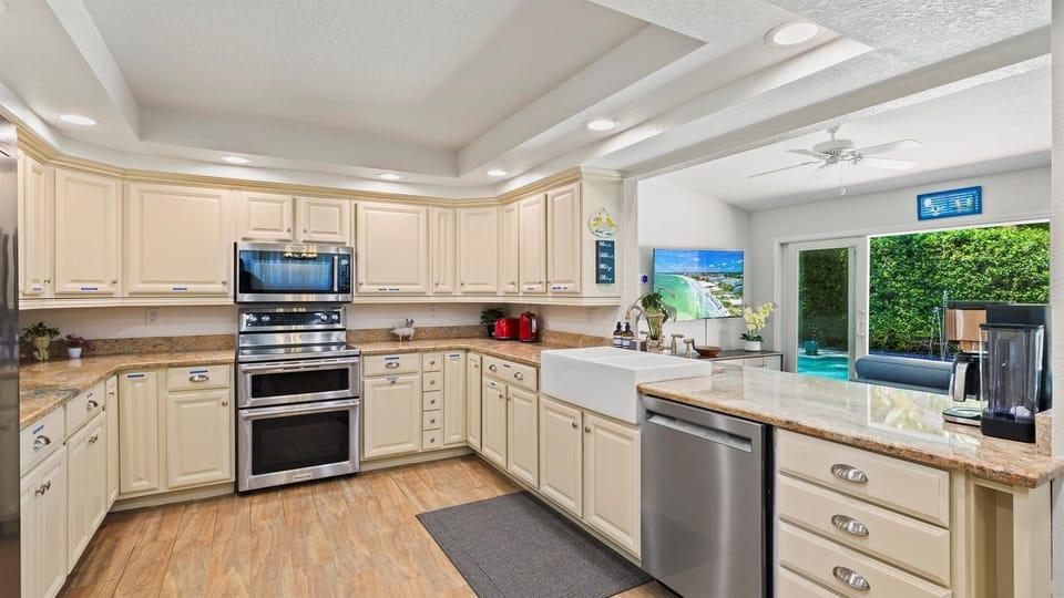 Whip up delicious meals in this spacious, fully equipped gourmet kitchen featuring double ovens, a built-in microwave, stainless steel appliances, granite countertops, a farmhouse sink, and custom cabinetry. Enjoy coffee from the high-end coffee station or
