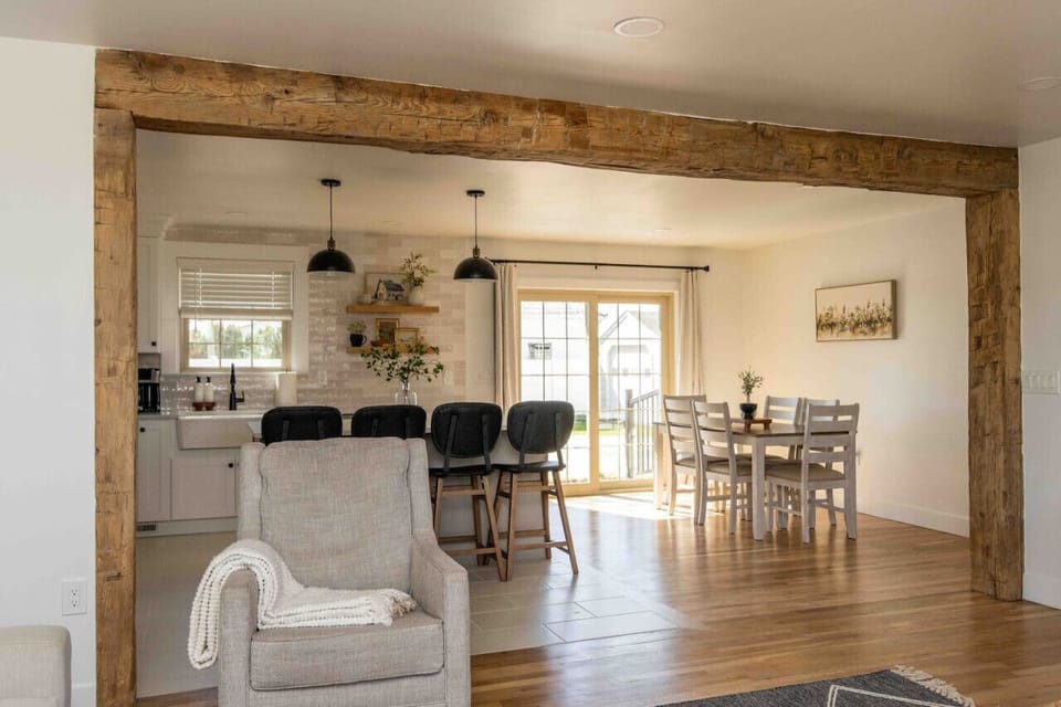 Seamless living & kitchen layout w/ exposed wood beam & barstool seating