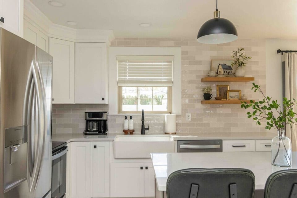 Fresh kitchen corner w/ stainless fridge, subway tile backsplash & floating wood shelves