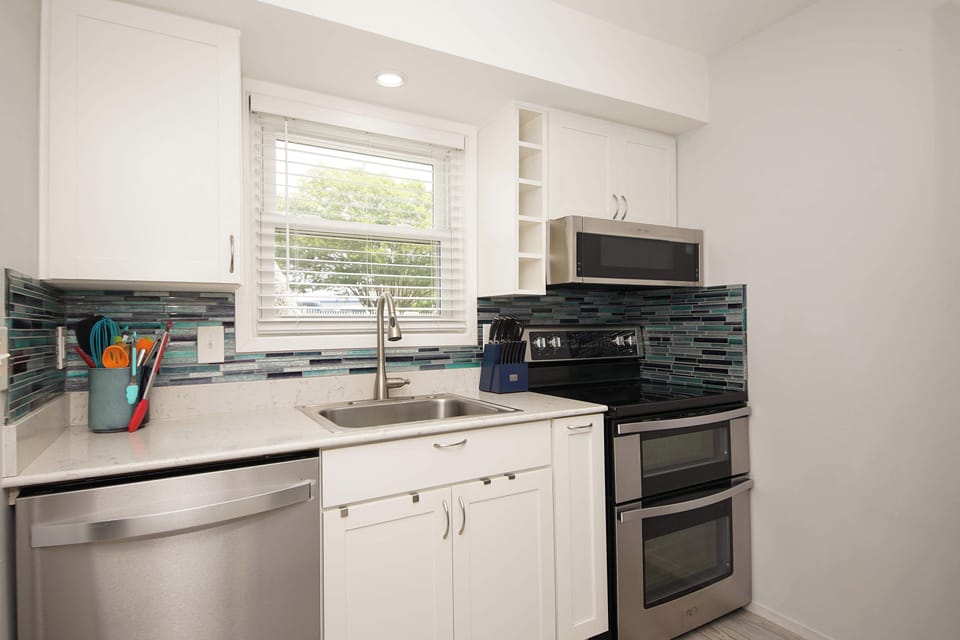 Your fully equipped kitchen features modern appliances and stylish tile backsplash, perfect for preparing memorable meals during your stay.