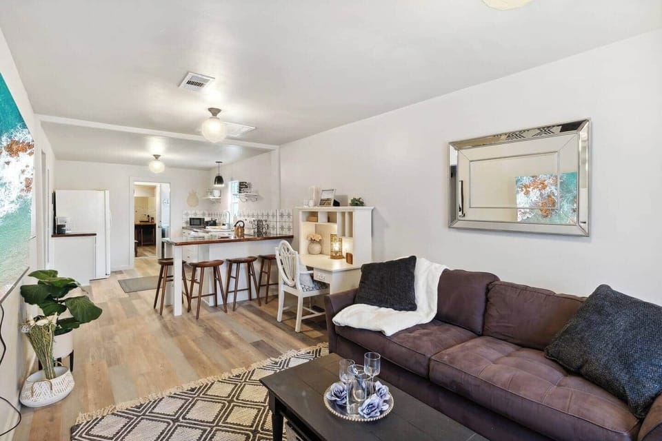 Main living room area includes two couches, a coffee table, small desk space, and breakfast nook
