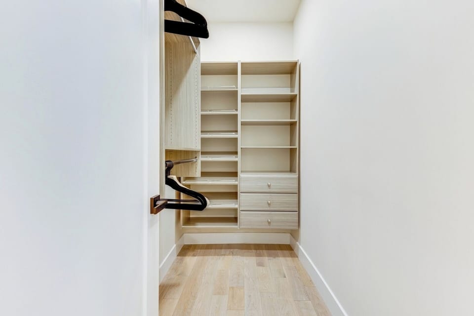 Custom-built walk-in closet in one of the Primary Bedrooms. 