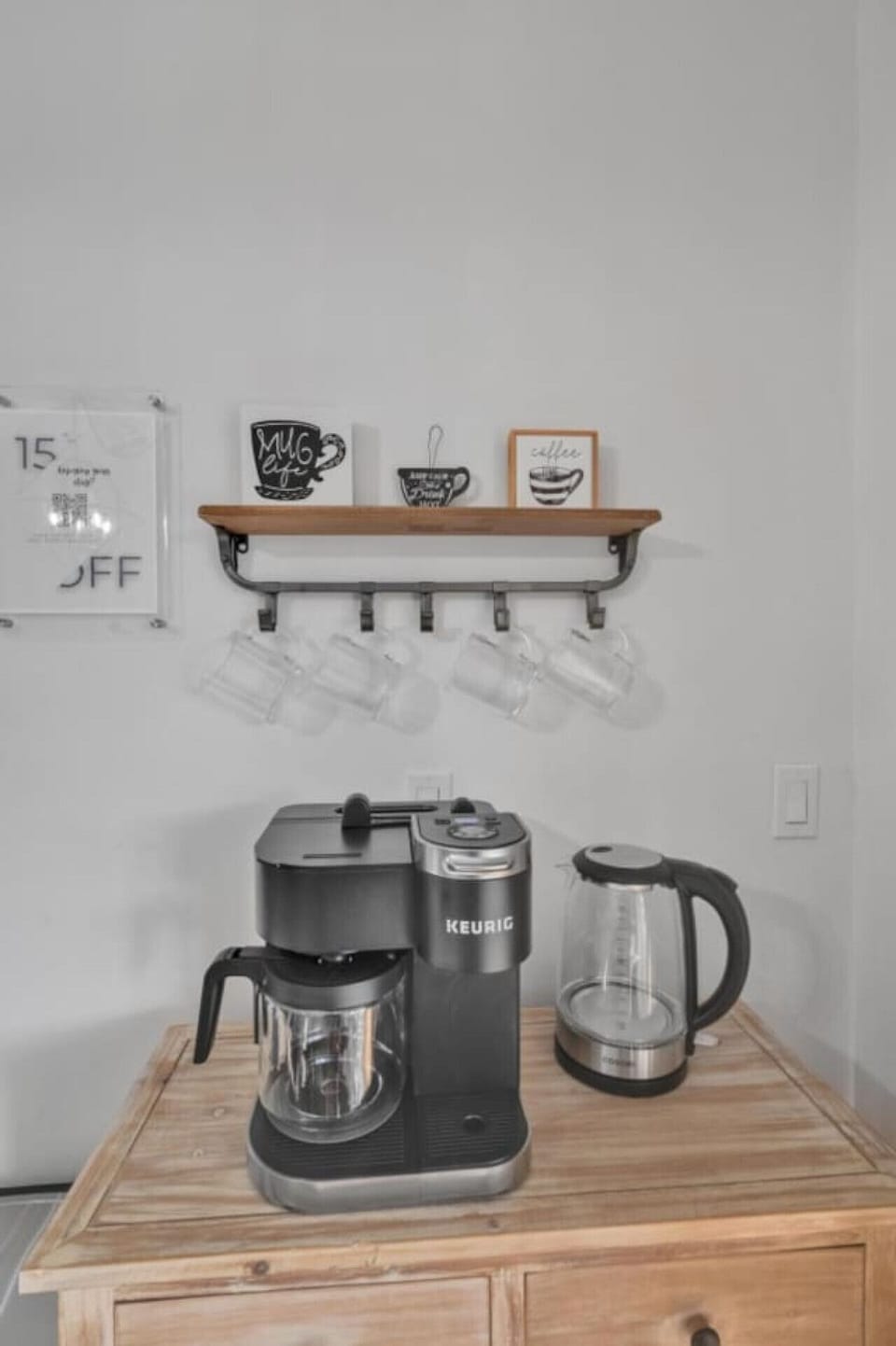Charming coffee station with a Keurig, glass kettle, mug shelf, and cozy decor accents.