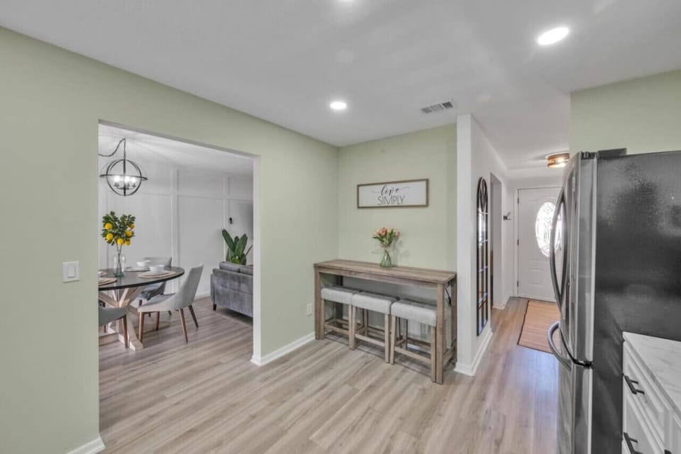 Open layout with a cozy dining area, breakfast bar, and welcoming entryway decor.