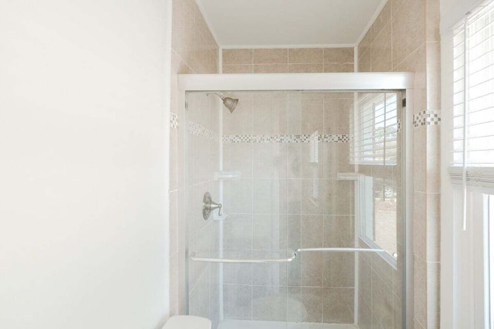 Clean & Modern Full Bathroom with Essentials. Includes shampoo, conditioner, body wash, and fresh towels.