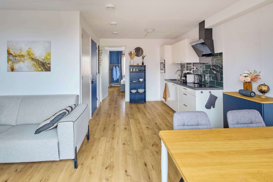 Spacious open-plan apartment with living, dining and kitchen area filled with natural light.