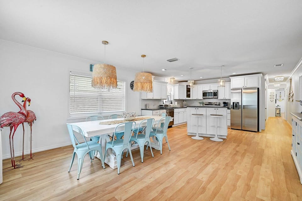 Enjoy a spacious, open-concept kitchen and dining area featuring a large table and countertop seating — ideal for family meals or casual breakfasts.