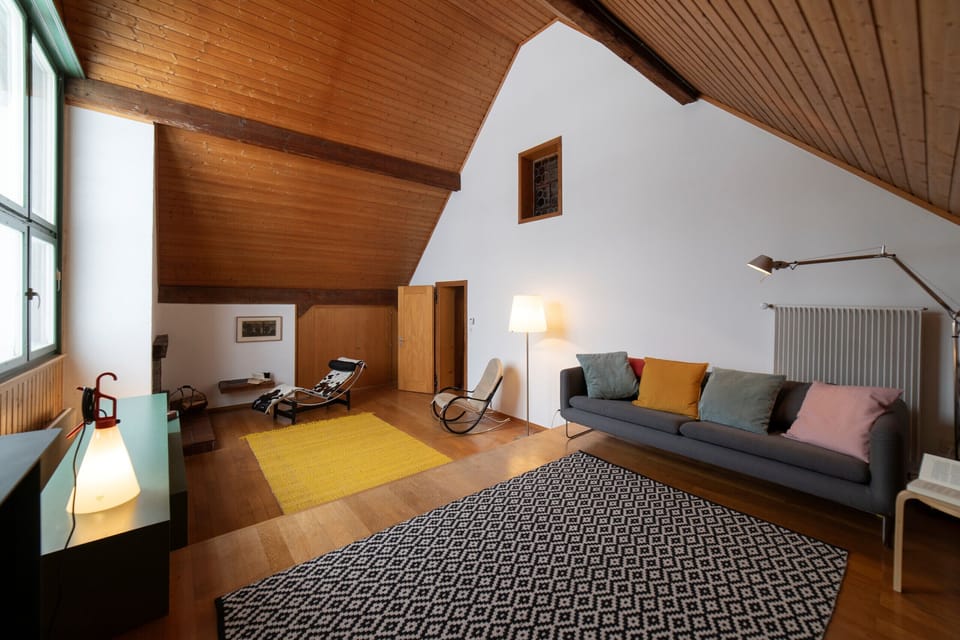 Cozy living area with sofa beneath a wooden ceiling