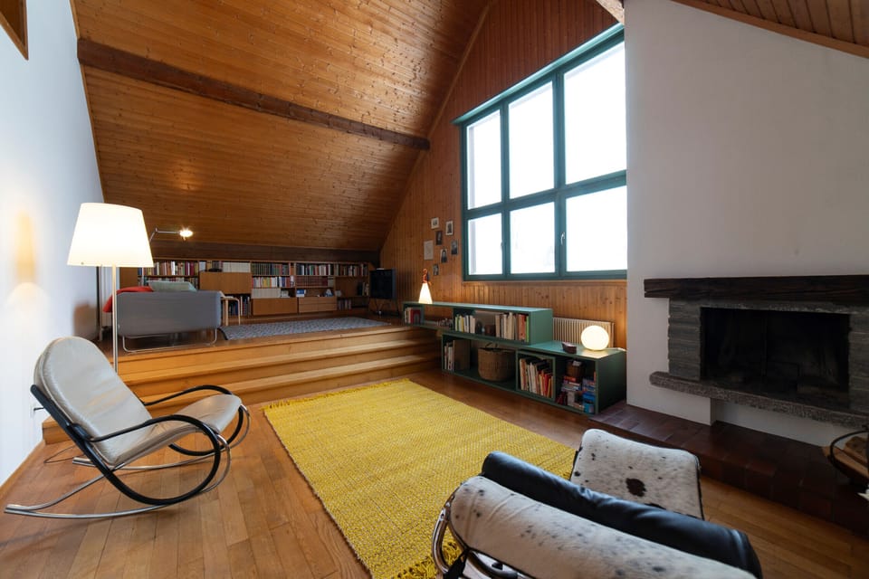Living area with fireplace, lounge chairs and large window