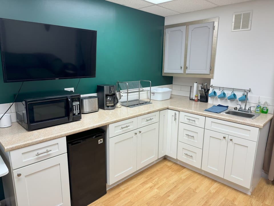 Large kitchen with microwave, hot plate, crockpot, toaster, and coffee maker
