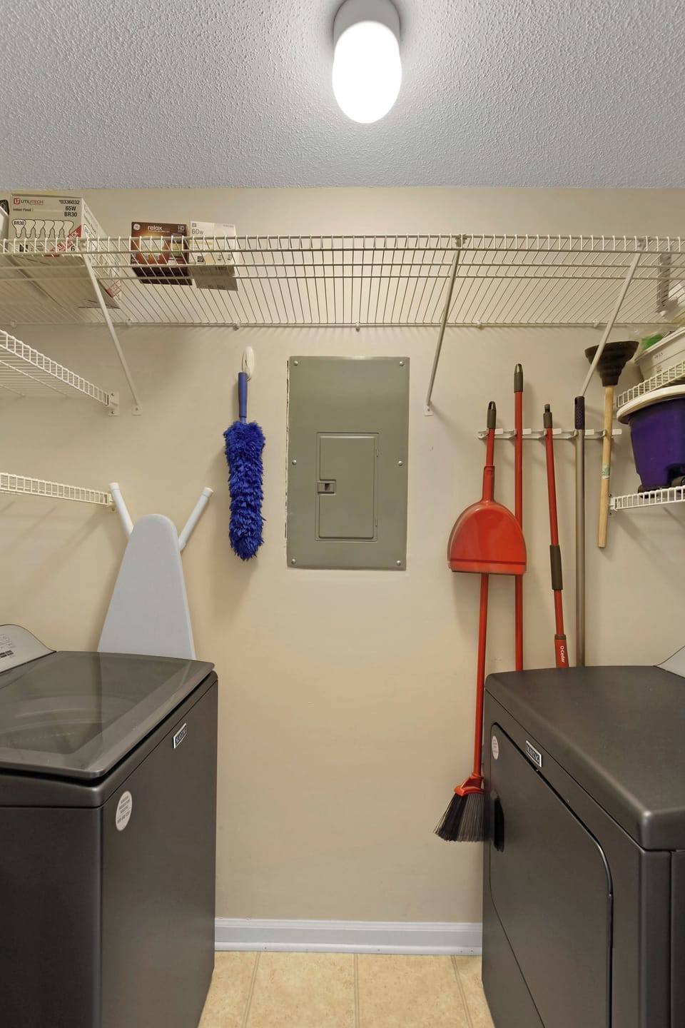 Laundry and Cleaning Supplies - Laundry area with washer, dryer, utility shelving, and cleaning tools.
