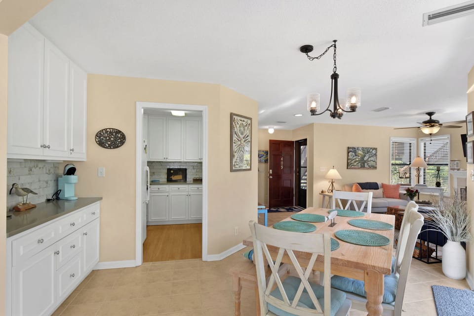 Kitchen Pass-Through and Dining - Kitchen pass-through beside the dining area with white cabinetry, counter space, and open sightline.