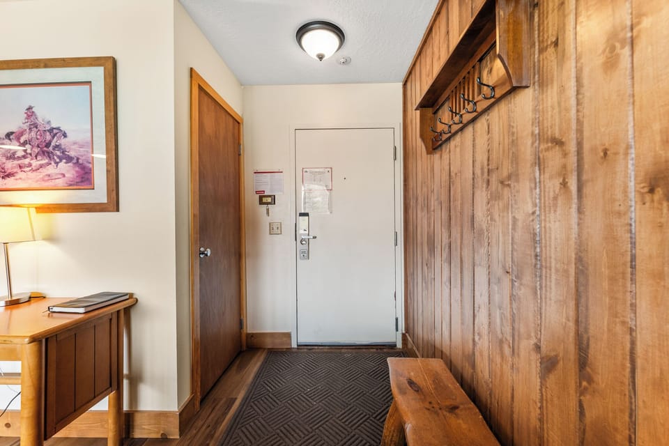 Your welcoming entryway features warm wood paneling and rustic touches, creating a cozy mountain lodge feel from the moment you arrive.