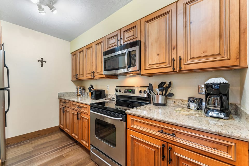 Your fully equipped kitchen features rich wood cabinets, granite counters, and modern appliances for creating delicious home-cooked meals.