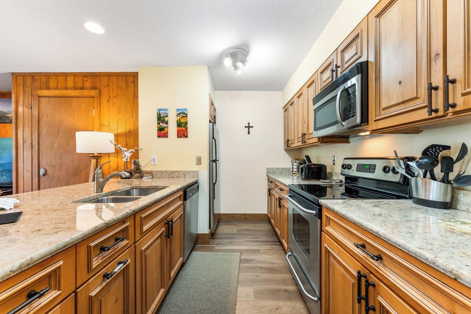 Your fully equipped kitchen awaits with granite counters, stainless appliances, and warm wood cabinets for memorable meal prep.