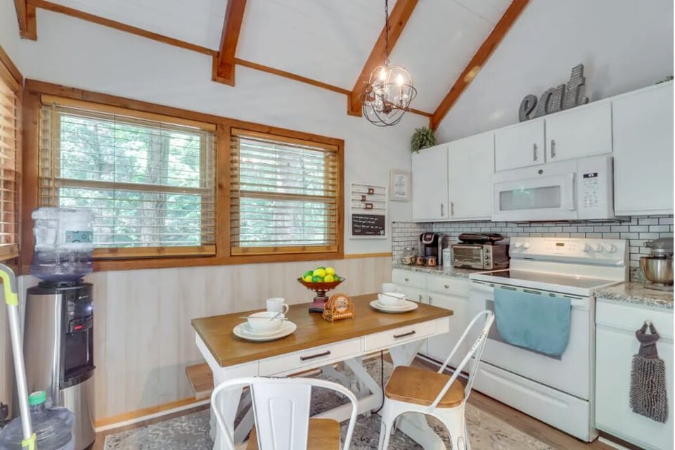 Dining table, water tank, Keurig, coffee, tea, toaster oven, stove, dishware