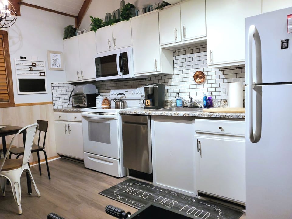 Dining table, water tank, Keurig, coffee, tea, toaster oven, stove, dishware