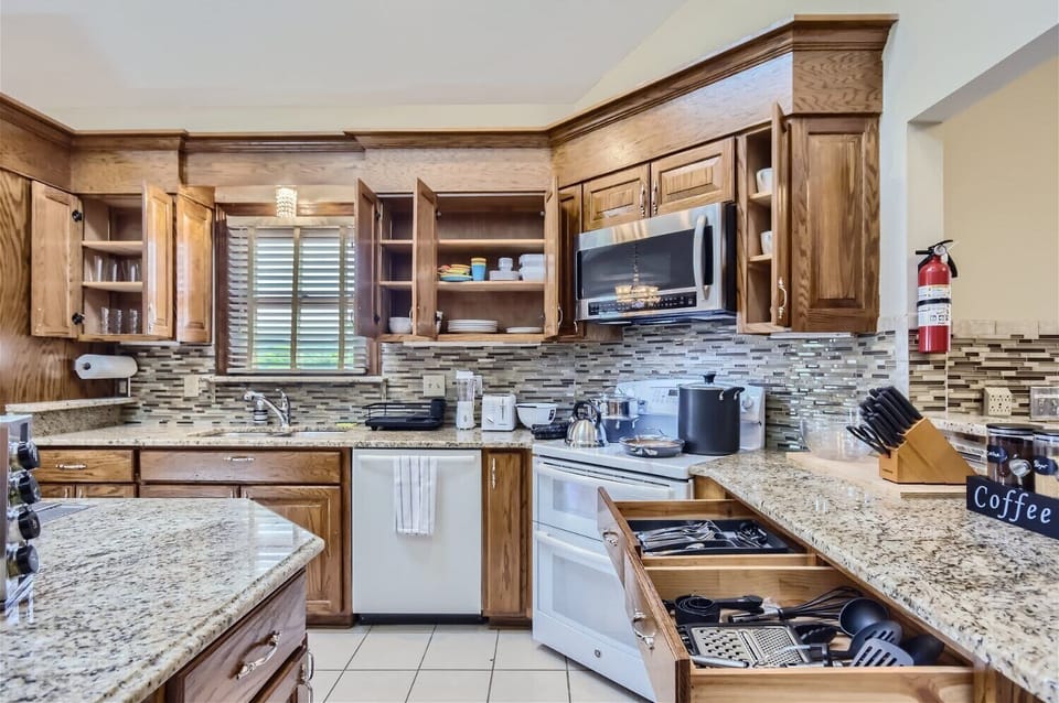 Enjoy the full kitchen with filtered water, refrigerator, freezer, oven, stove, microwave, dishwasher, coffee, creamers, mixers, spices, pots, pans, cooking supplies, cutlery, cups, plates, bowls, utensils, small appliances, and many more essentials!
