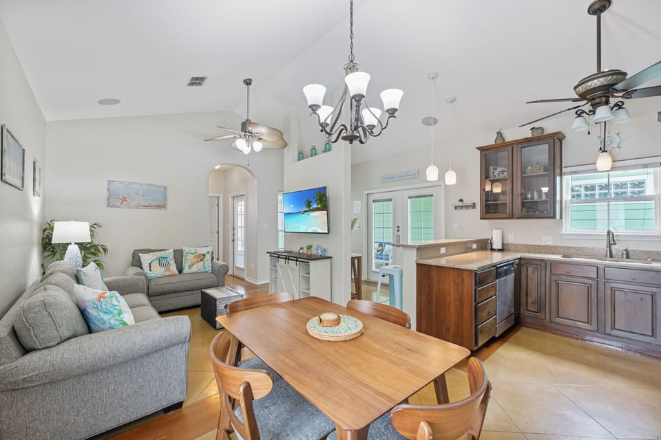 Relax in your open-concept living space where coastal charm meets modern comfort, complete with full kitchen and dining area.