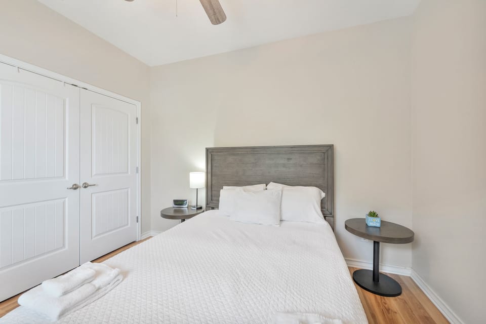 Slip into crisp linens and let the coastal breeze from the ceiling fan lull you to sleep in this serene bedroom retreat.