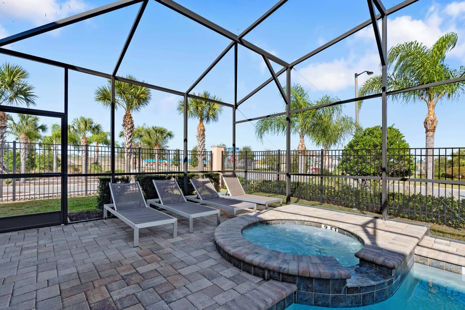 Bask in the sunshine by the sparkling pool, surrounded by lush palm trees and a spacious patio area. Relax on the stylish lounge chairs or unwind in the inviting spa, all within a screened enclosure for ultimate comfort.
