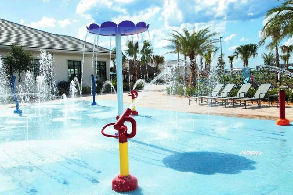 Enjoy a splash at this vibrant water pad, with colorful features and a refreshing blue surface. Surrounded by swaying palm trees and comfy lounge chairs, it's the perfect outdoor oasis for family fun and relaxation.