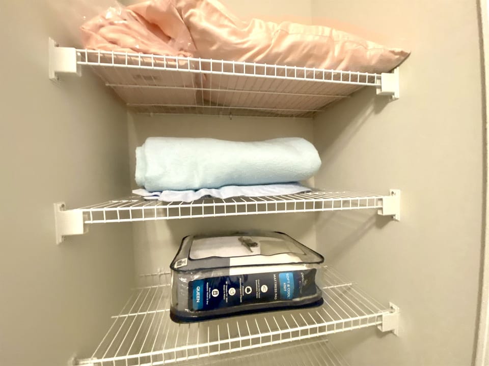 Master bedroom closet with extra pillow, blankets and set of linens for living room sleeper 
