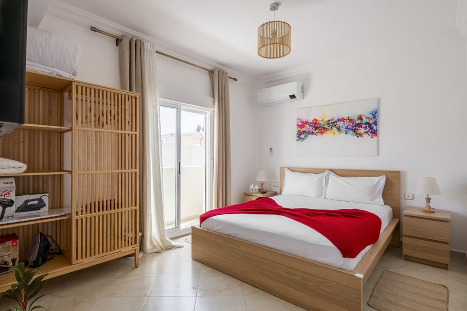 Bedroom with large bed ensures a restful sleep, while a spacious closet offers ample storage for your belongings. The highlight of the room is undoubtedly the private balcony accessible through a sliding glass door.